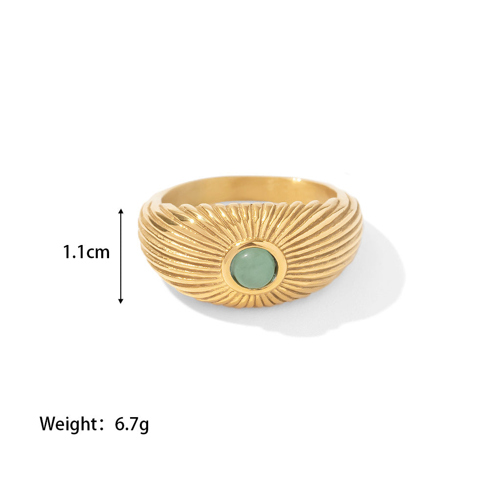 18K Gold Plated Green Stone Sun Ring displayed on satin fabric, featuring a sun-shaped design with a green stone.