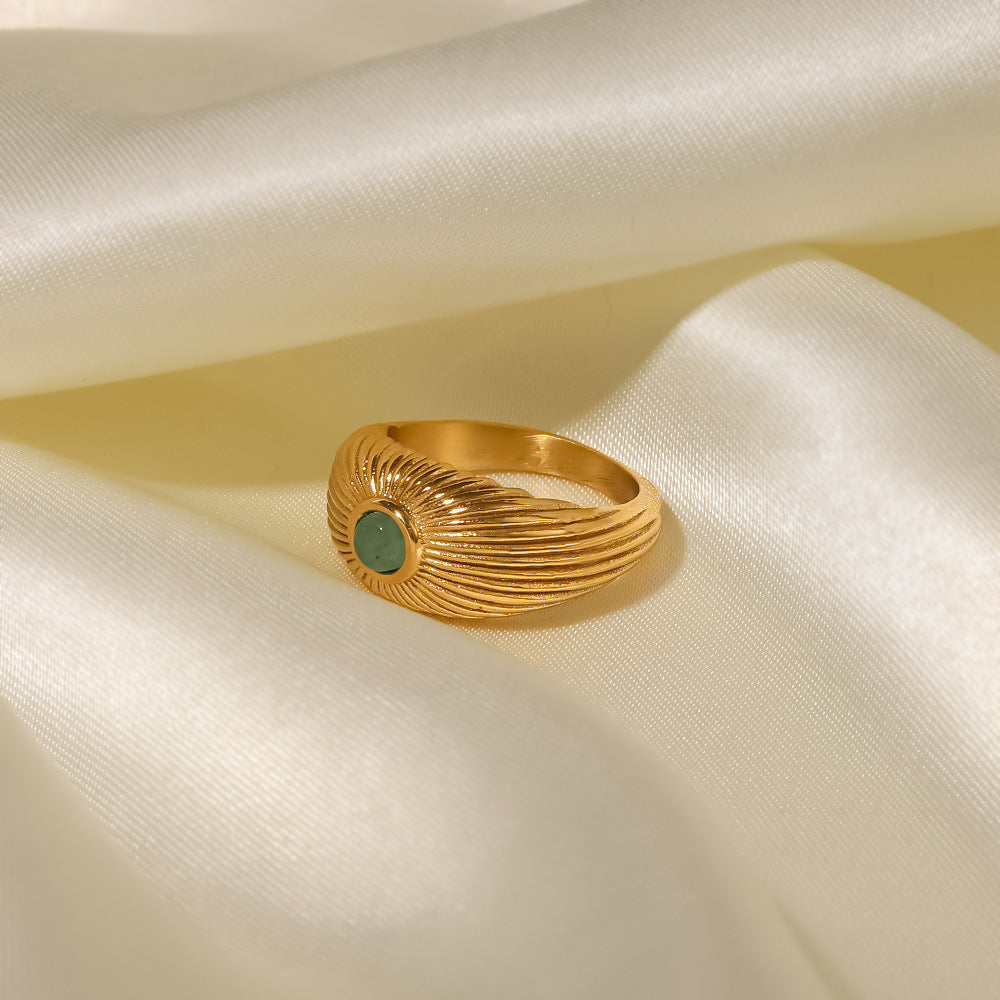18K Gold Plated Green Stone Sun Ring displayed on satin fabric, featuring a sun-shaped design with a green stone.